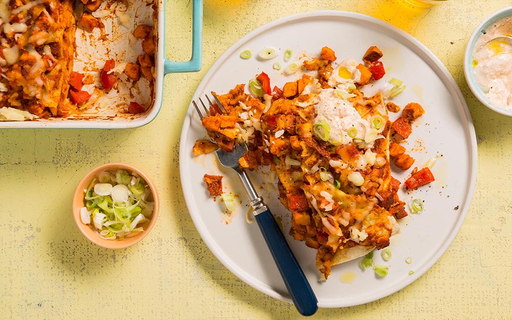 Cheesy Monterey Tortilla Bake with sweet potatoes and spiced sour cream,
